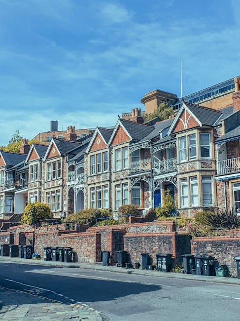 A row of ornate Victorian terraced buildings in Gipsy Hill, with the facade painted in pastel blue and vibrant pink colors. The buildings feature large, evenly spaced sash windows with decorative whit